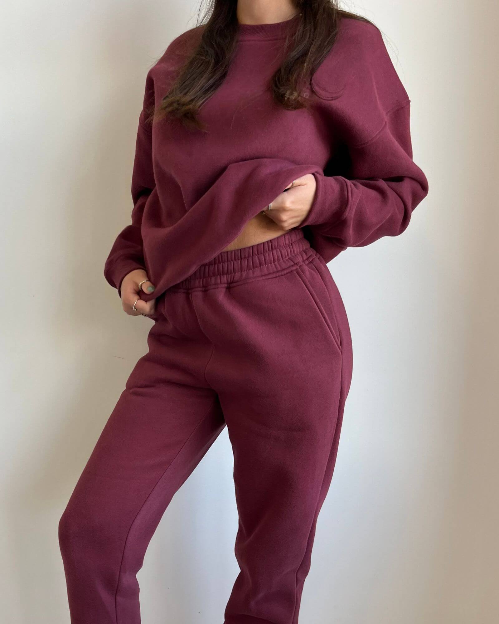 Close-up of a girl wearing a cute burgundy matching set in front of a white background.