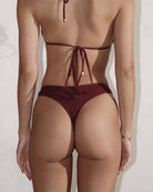 Back view of a girl wearing a cute burgundy rib bikini.