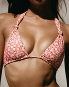 Close-up of a girl wearing a cute floral peach bikini top.