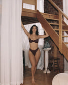 Beautiful girl posing in a house wearing a cute burgundy rib bikini.