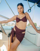 Beautiful girl is on a boat wearing a cute burgundy rib bikini along with the matching sarong.